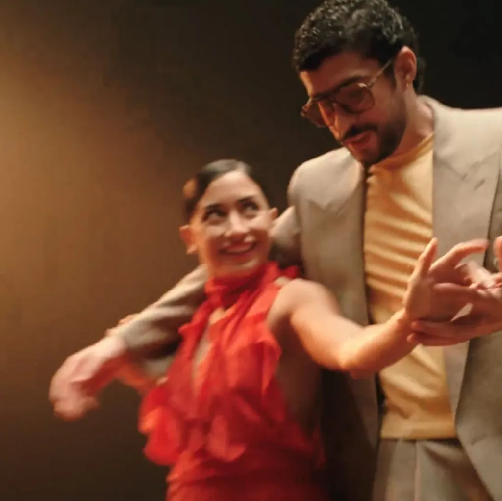 Bad Bunny dancing with a woman in a red dress.