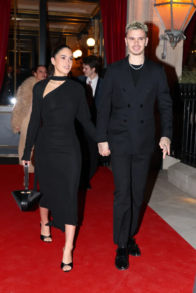 Romeo Beckham and Kim Turnbull holding hands on a red carpet.