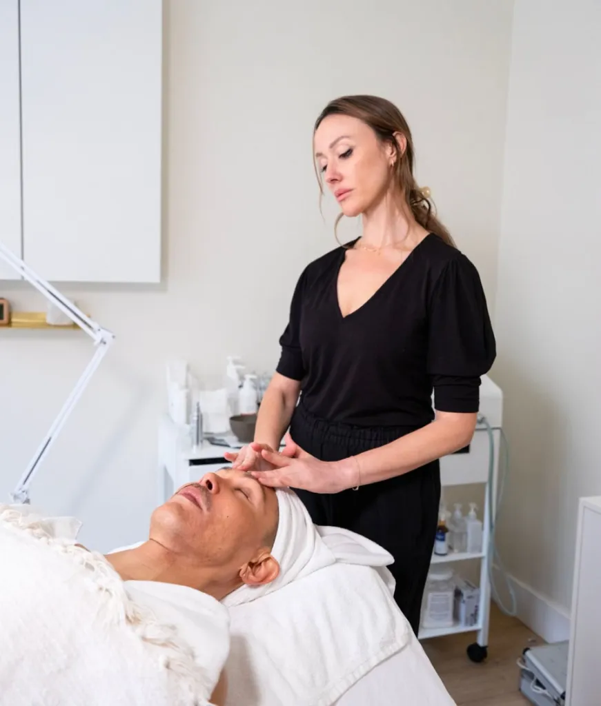 Esthetician giving a facial to a client.