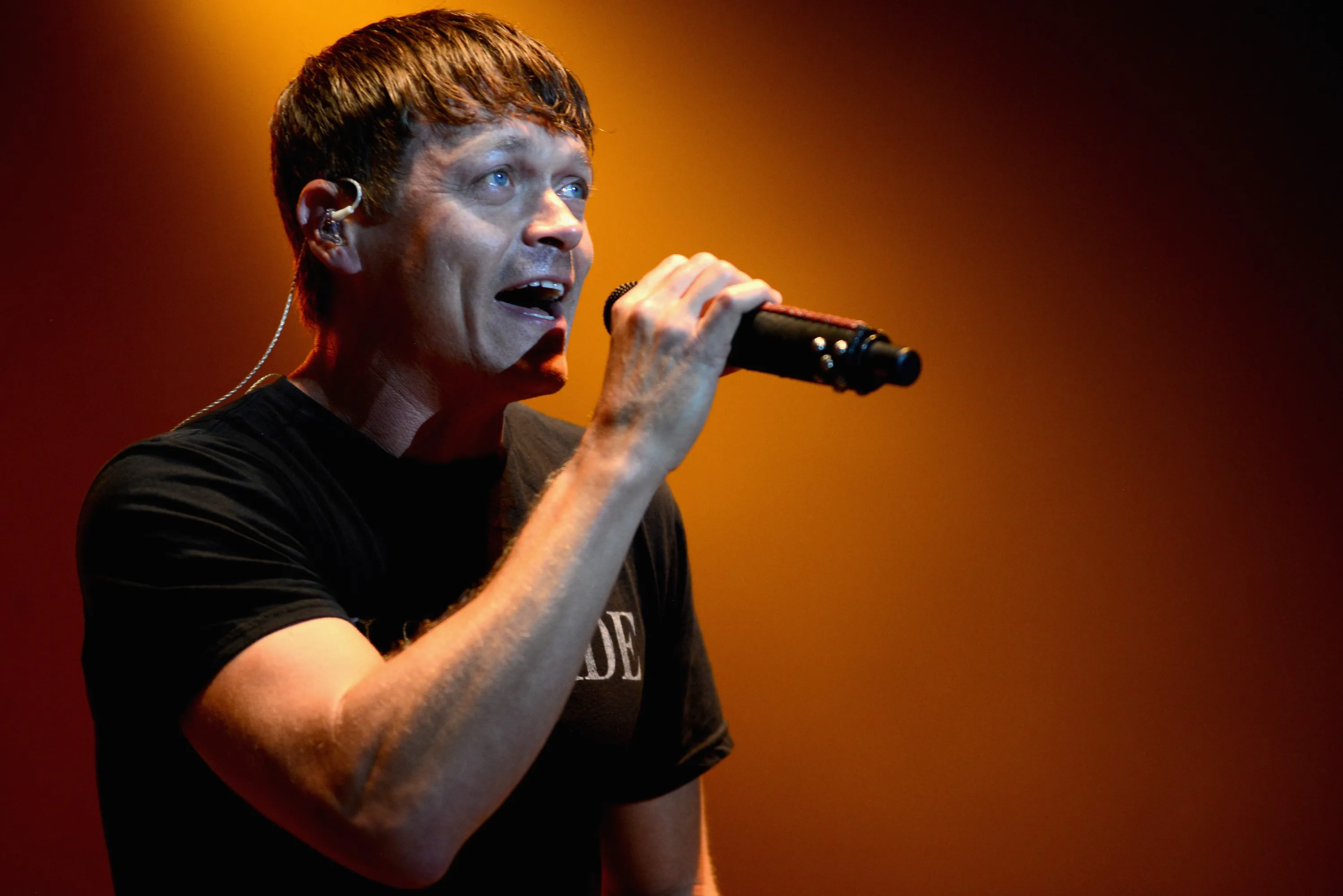 Brad Arnold of Three Doors Down sings into a microphone during a live performance.