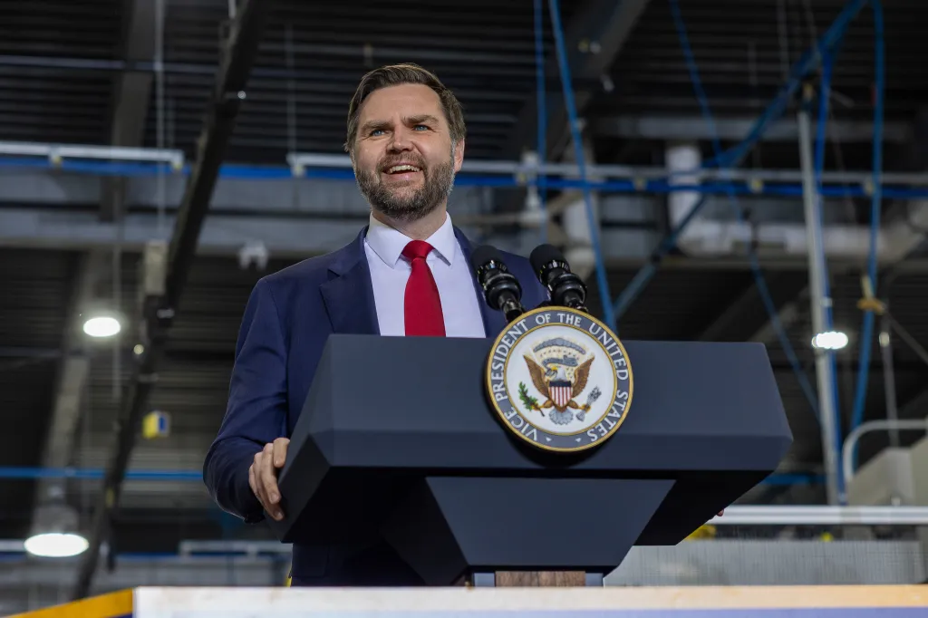 JD Vance speaking at a podium with the seal of the Vice President of the United States.