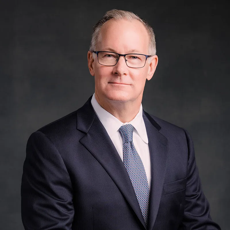 Jim Hundley smiling in a suit and tie.