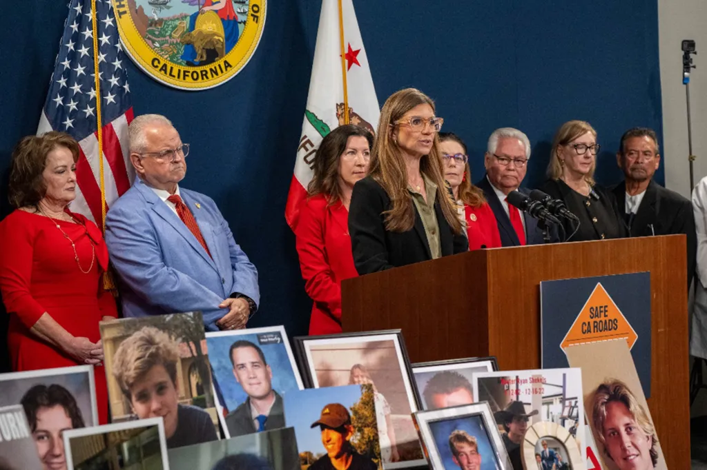 Woman speaking at a podium while a group of people and portraits of victims of drunk driving accidents stand nearby.