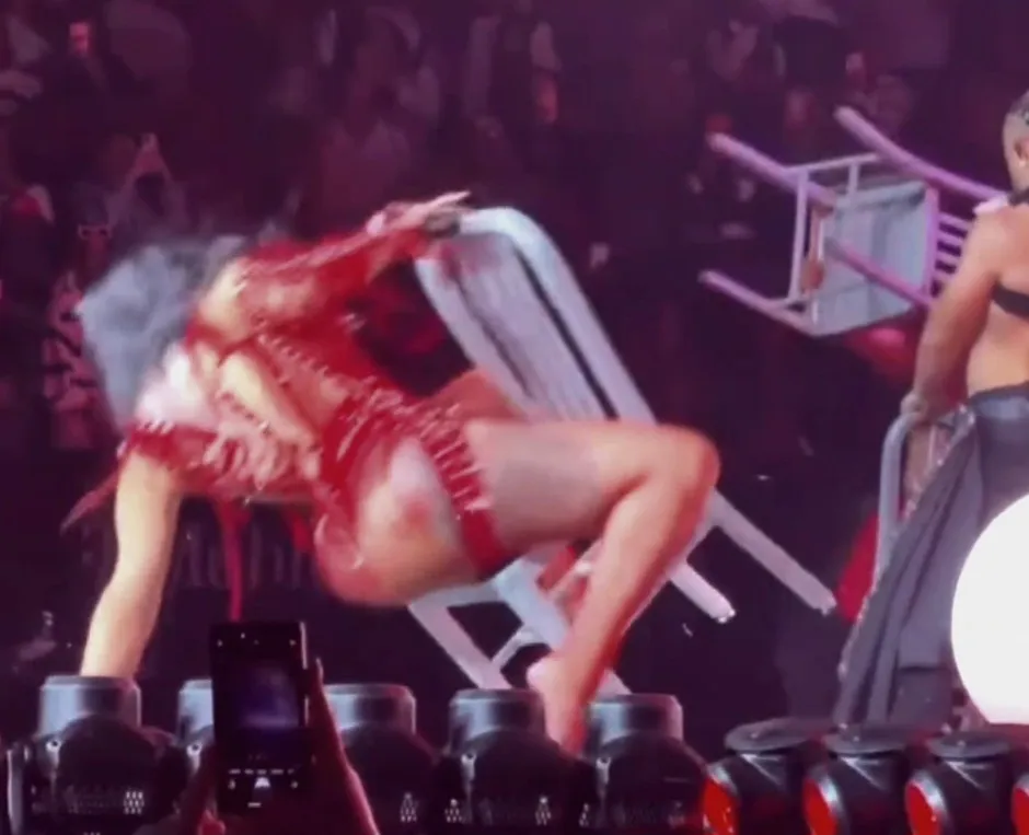 Cardi B falling backwards out of a chair during a concert.