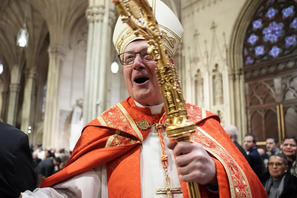 Cardinal Timothy Dolan smiling and holding a golden crosier during an installation mass.