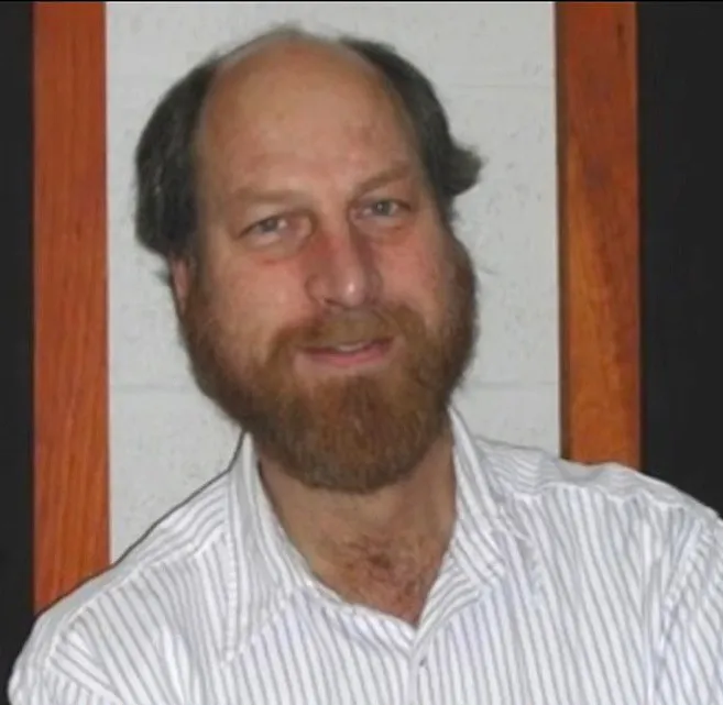 Headshot of Carl Grillmair, a white man with a balding head, brown hair, and a full brown beard, smiling.