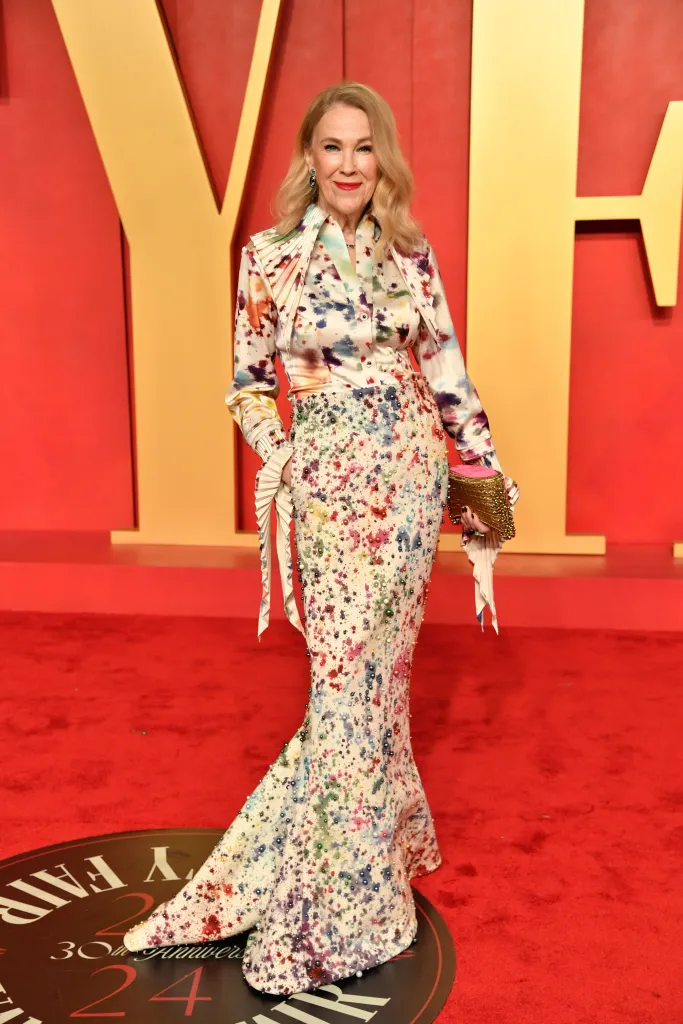 Catherine O'Hara on the red carpet in a colorful, paint-splatter pattern gown.