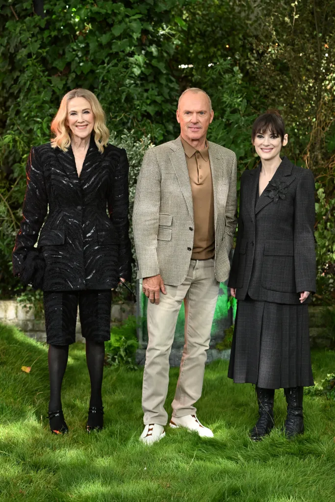 Catherine O'Hara, Michael Keaton, and Winona Ryder posing outdoors.