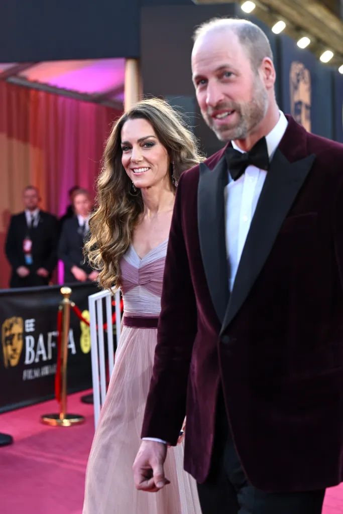 Catherine, Princess of Wales, in a pink gown, and Prince William, Prince of Wales, in a velvet tuxedo, arrive at the EE BAFTA Film Awards.