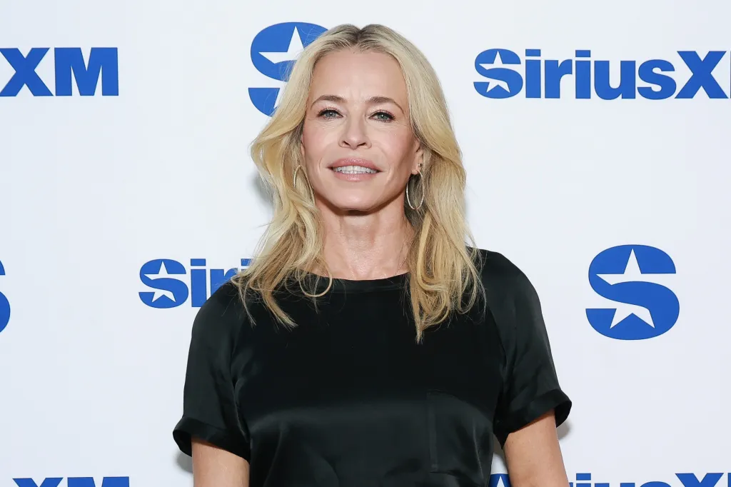 Chelsea Handler smiling in front of a white background with blue SiriusXM logos.