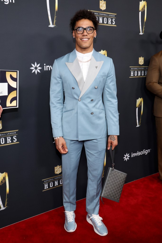 Christian Gonzalez in a light blue suit and glasses on a red carpet.