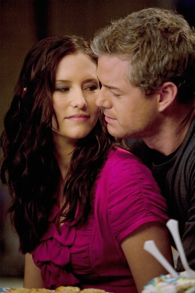 Chyler Leigh looks over Eric Dane's shoulder, intimately leaning in.