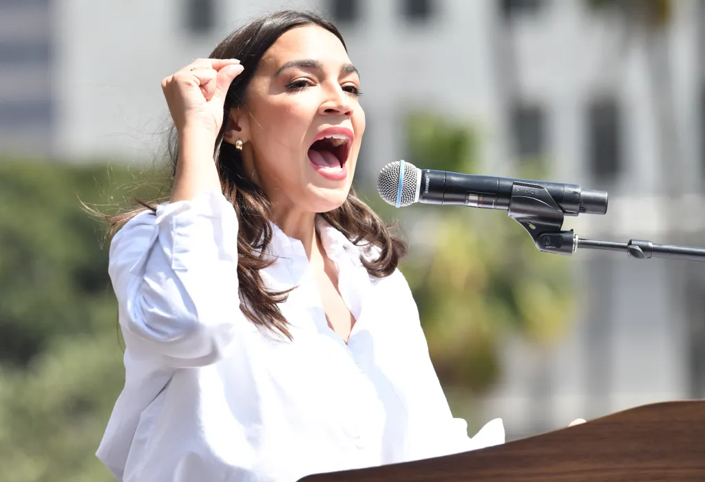 Congresswoman Alexandria Ocasio-Cortez speaking into a microphone at the 
