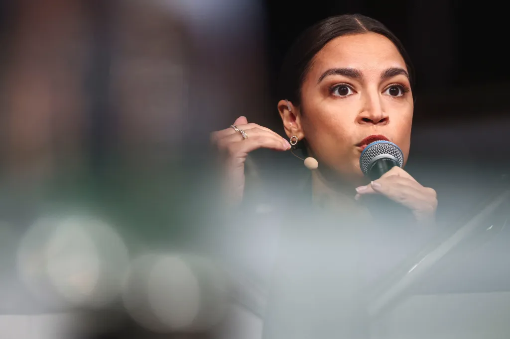 U.S. Representative Alexandria Ocasio-Cortez speaking into a microphone at the Munich Security Conference.