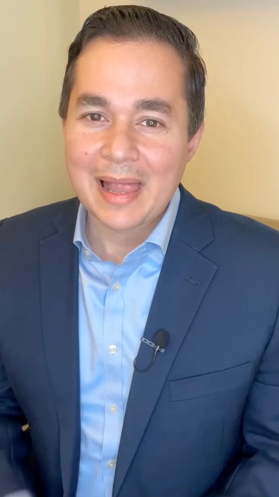 Dan Illouz, a Canadian-born Israeli politician, wearing a blue suit jacket and light blue collared shirt with a lavalier microphone attached.