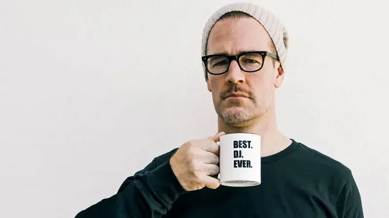 James Van Der Beek as Diplo, holding a mug that says 