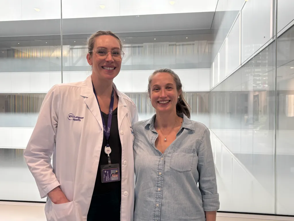 Dr. Abigail Campbell and a pregnant woman stand side by side, smiling at the camera.