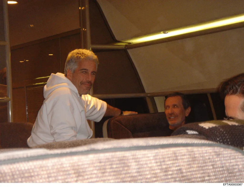 Jeffrey Epstein smiles inside his private jet.