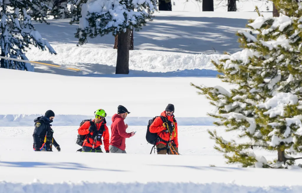 Emergency crews walking through deep snow.