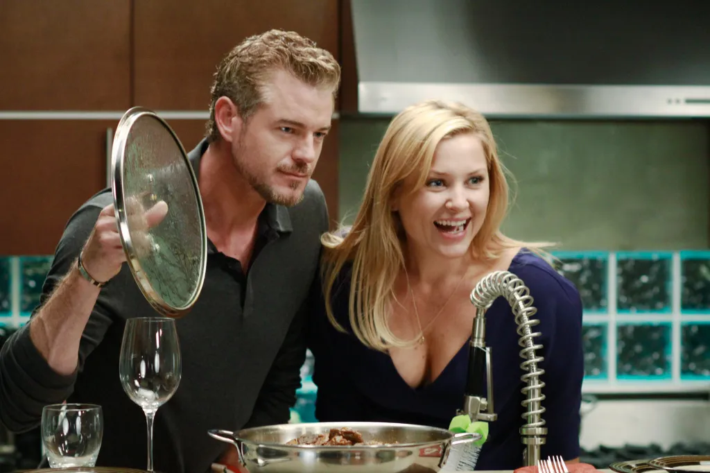 Eric Dane and Jessica Capshaw cooking in a kitchen.