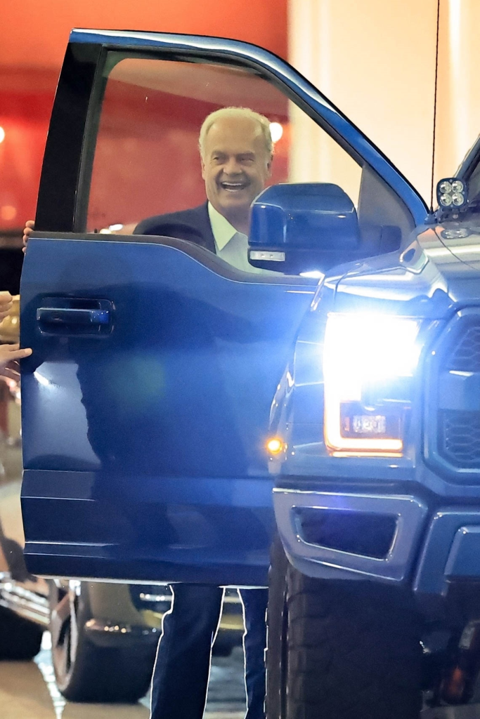 Kelsey Grammer smiling and laughing while exiting a blue truck.