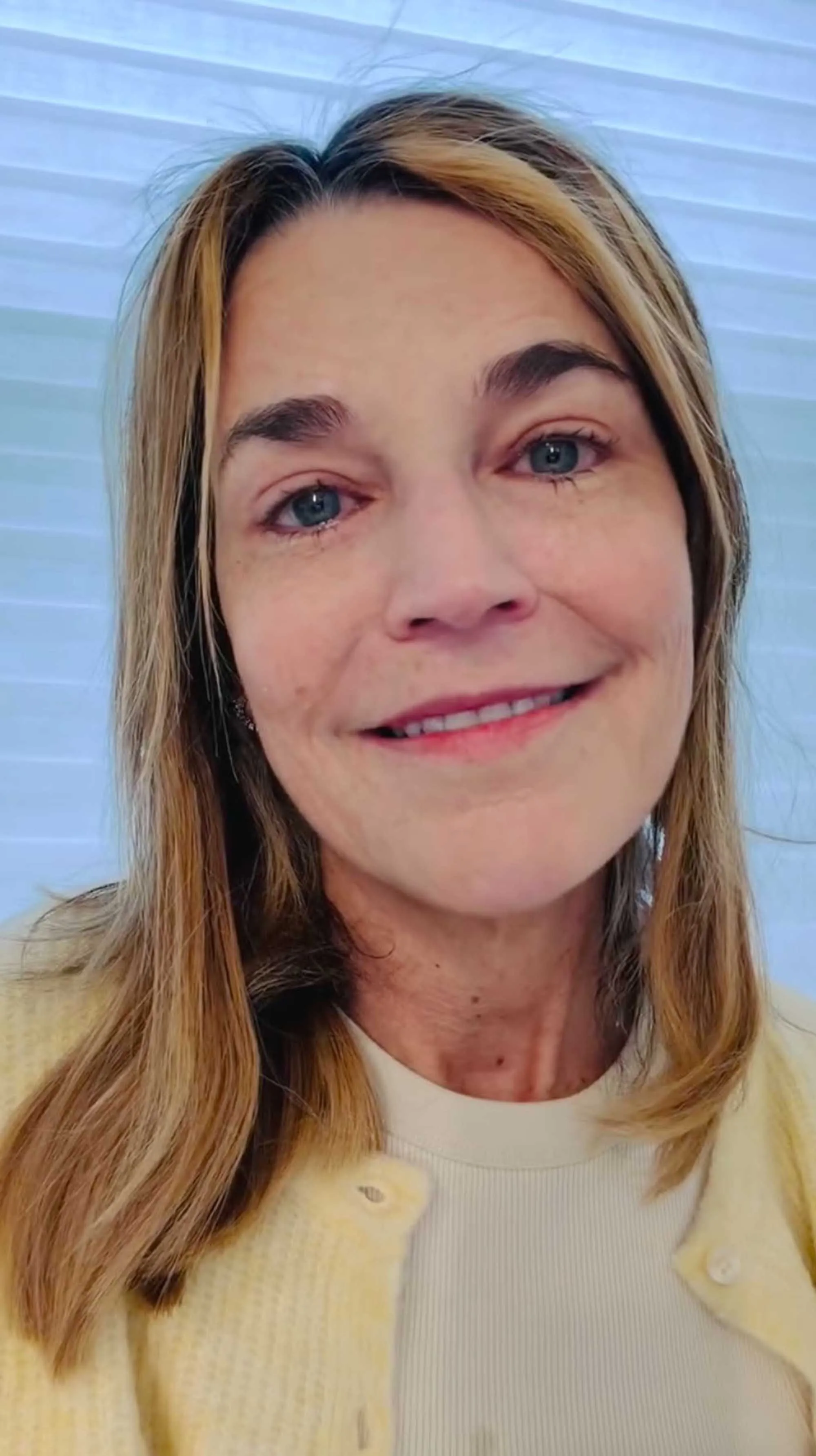 A woman with blonde hair, fair skin, and light blue eyes smiles, asking for help to find her mother.