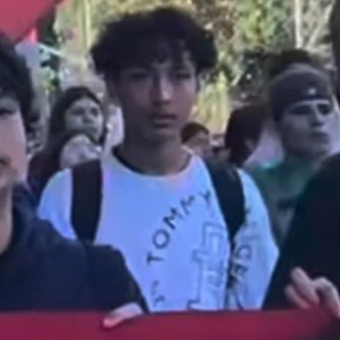 Students marching with a red banner during an anti-ICE protest.