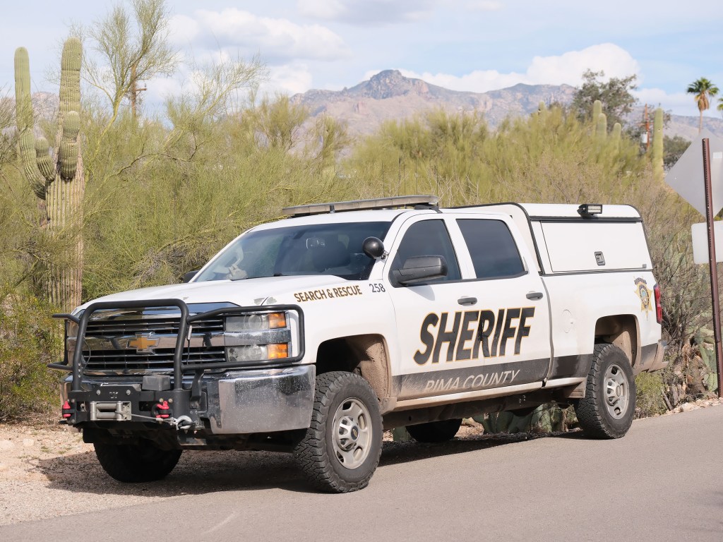A Pima County Sheriff's Search and Rescue truck is parked in a desert landscape.