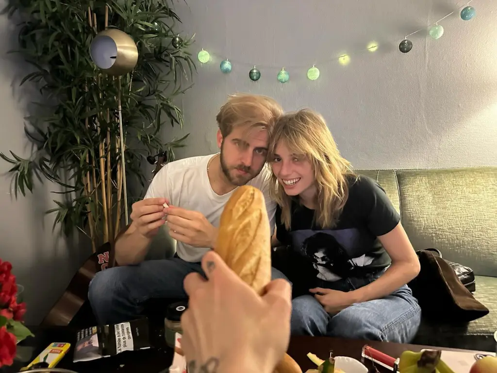 Christian Lee Hutson and Maya Hawke sitting on a couch.