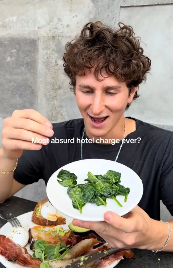 Food blogger Jack Goldburg holding a small plate of spinach.