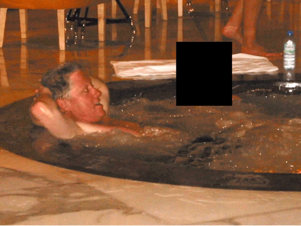 Former President Bill Clinton relaxing in a hot tub with his arms behind his head, with a redacted figure partially visible in the background.