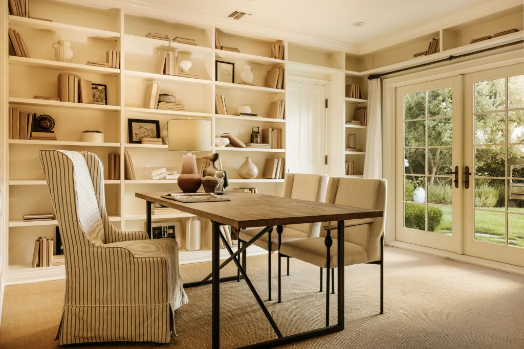 A cream-colored home office opens to the outdoors