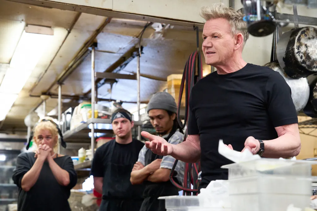 Gordon Ramsay addressing restaurant staff in a kitchen.