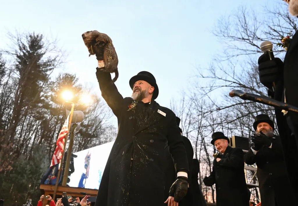A.J. Dereume holds Punxsutawney Phil above his head during a Groundhog Day celebration.