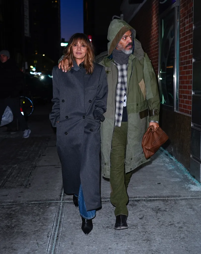 Halle Berry and Van Hunt walking arm-in-arm on a New York City street at night.