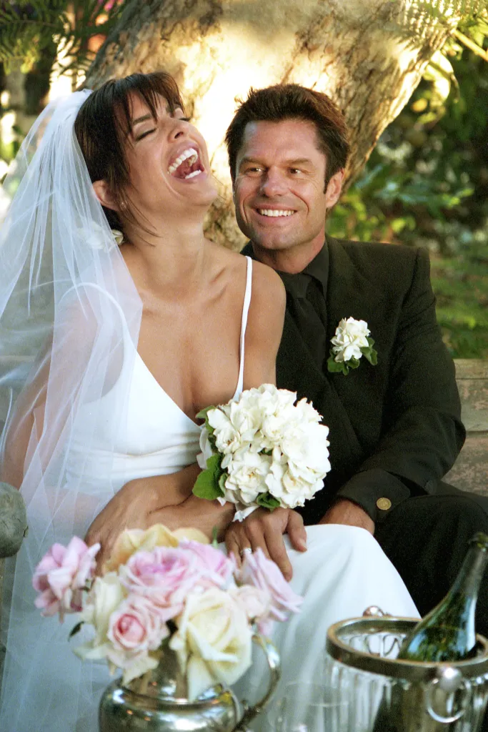 Actors Lisa Rinna and Harry Hamlin, in wedding attire, share a laugh in their garden.