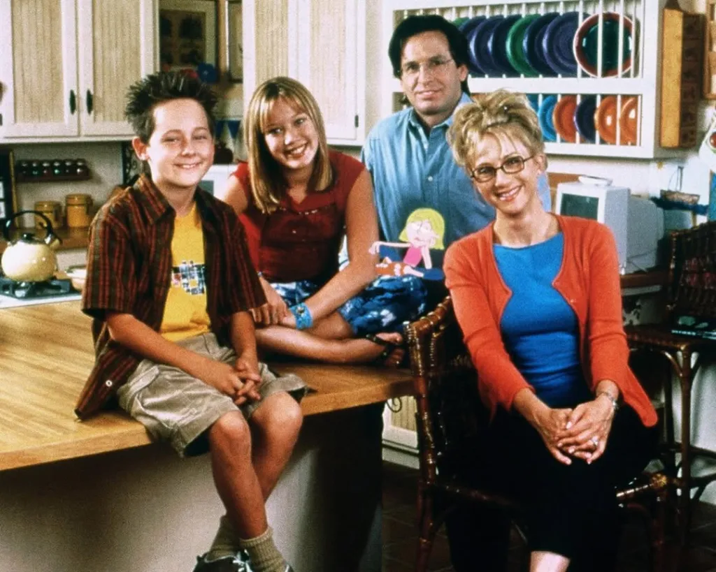 The cast of Lizzie McGuire poses in a kitchen.
