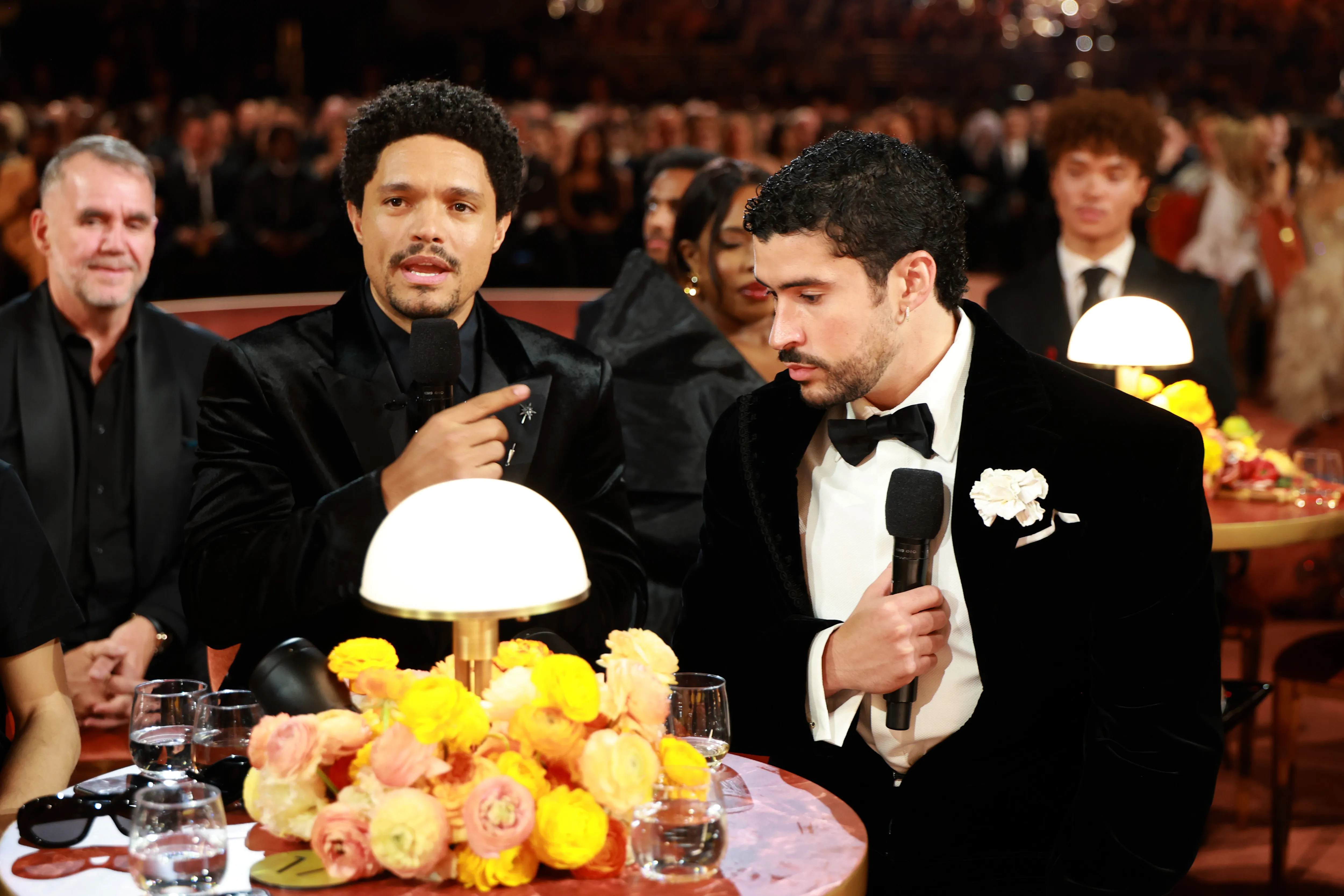 Trevor Noah and Bad Bunny at the Grammys 2026 sitting at a table and talking 