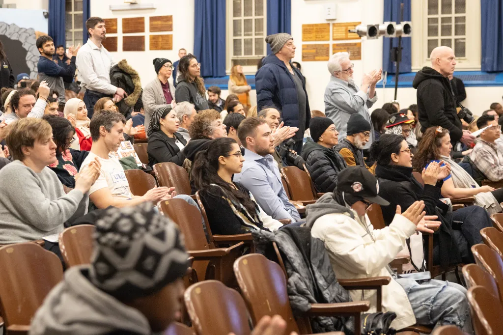 Attendees clap during a town hall hosted by Rep. Alexandria Ocasio-Cortez in Queens.