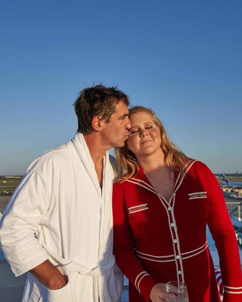 Amy Schumer being kissed on the forehead by her husband, Chris Fischer.