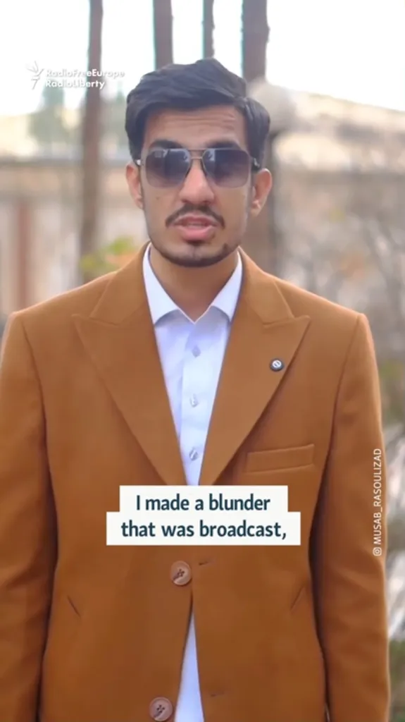 Musab Rasoulizad, an Iranian broadcast reporter, wearing a brown suit jacket and sunglasses, speaks with text overlay 