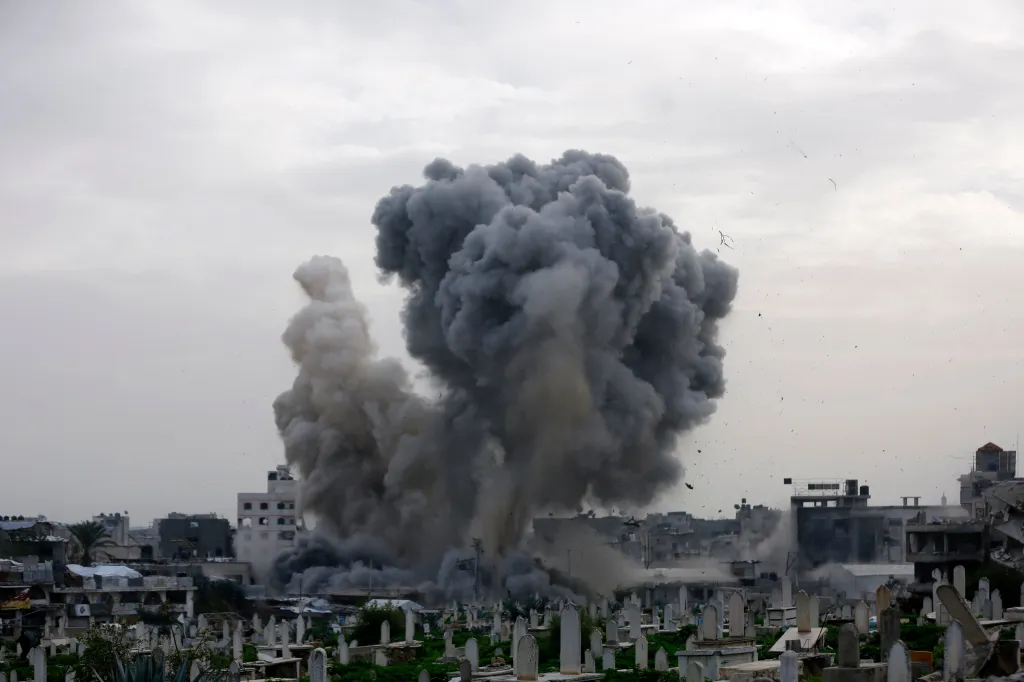 A large plume of dark smoke rising from a residential building in Gaza City after an Israeli airstrike.