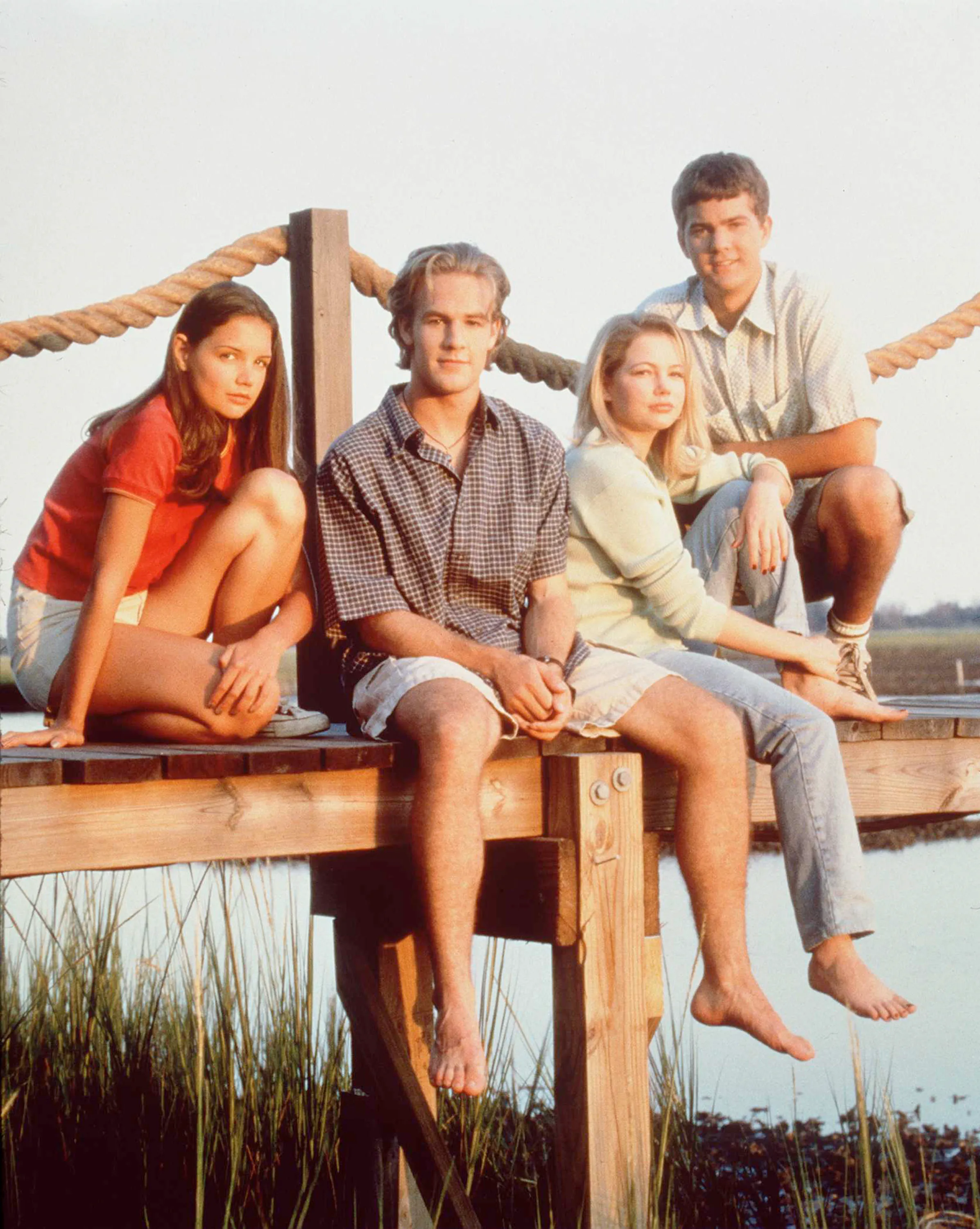 The cast of Dawson's Creek sitting on a pier.