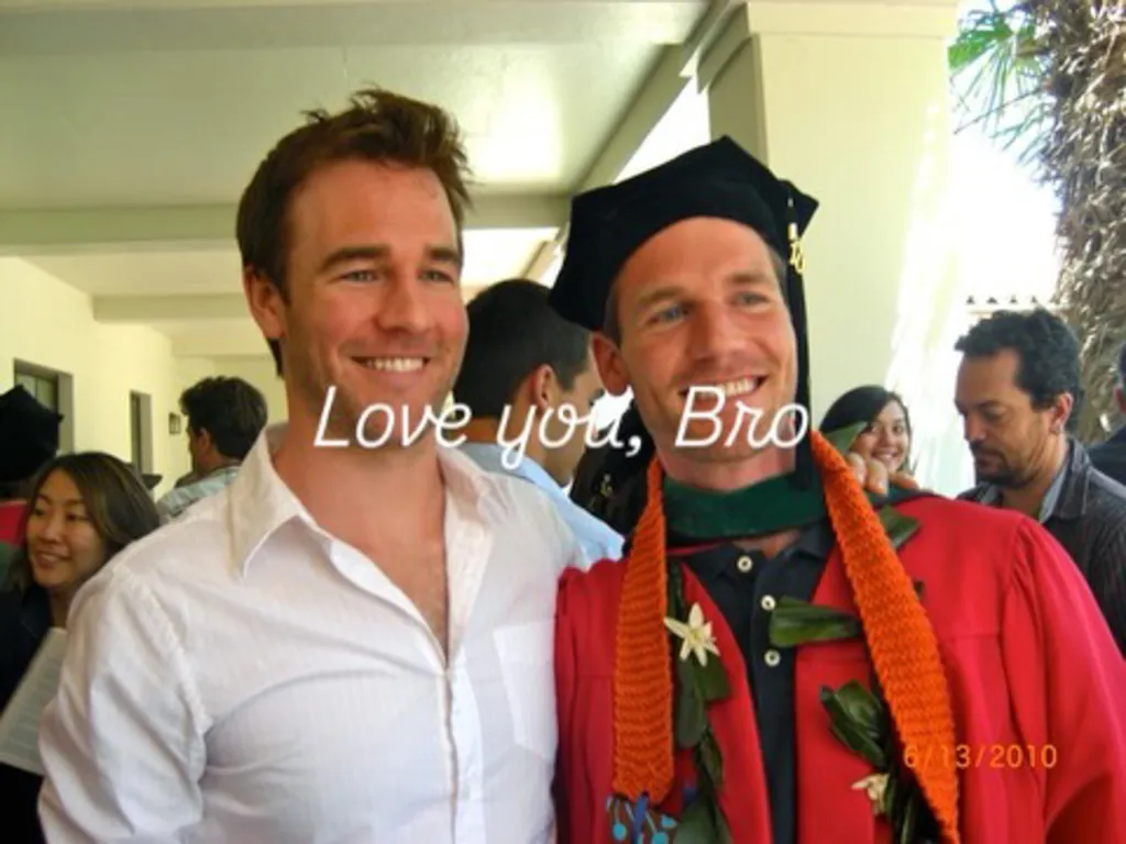 James Van Der Beek smiling next to his brother who is wearing a graduation cap and gown.