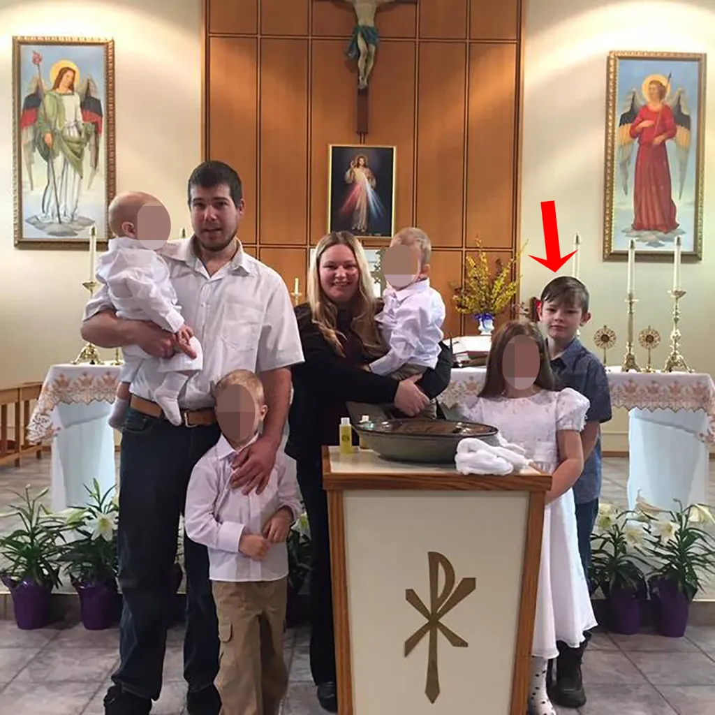 Family photo of Jennifer Strang, with her husband, and four children in a church, with a red arrow pointing to Jesse Strang.