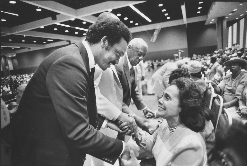 Jesse Jackson and Coretta Scott King shaking hands.