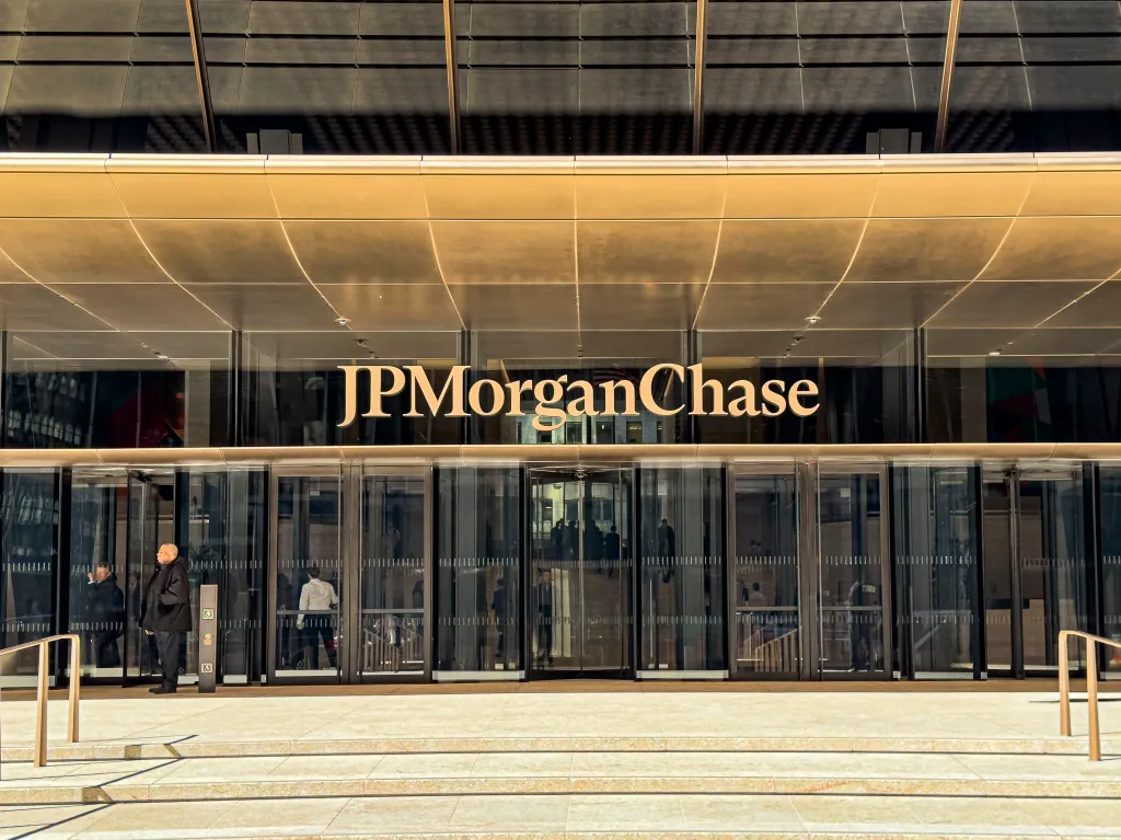Exterior entrance of the JPMorgan Chase Building with its logo above revolving glass doors.