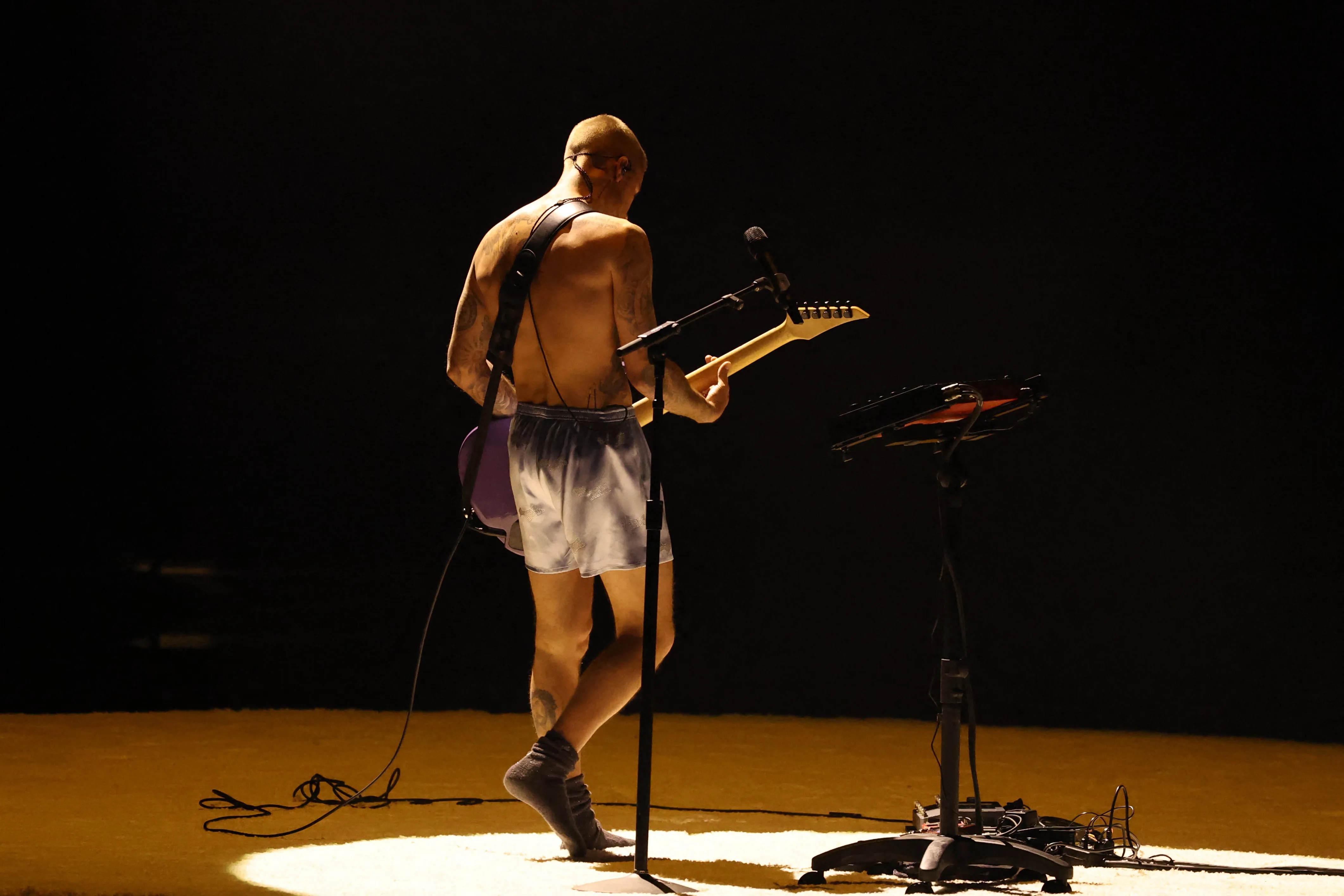Justin Bieber playing a guitar onstage at the 2026 Grammys wearing only boxers