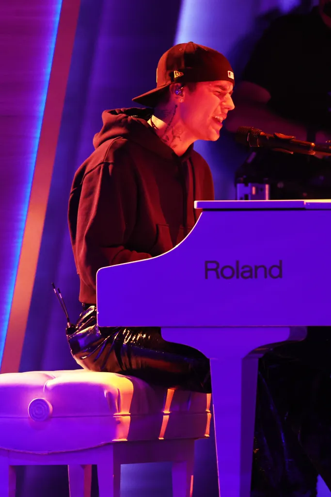 Justin Bieber performing at the 64th Annual GRAMMY Awards, playing a white Roland piano.