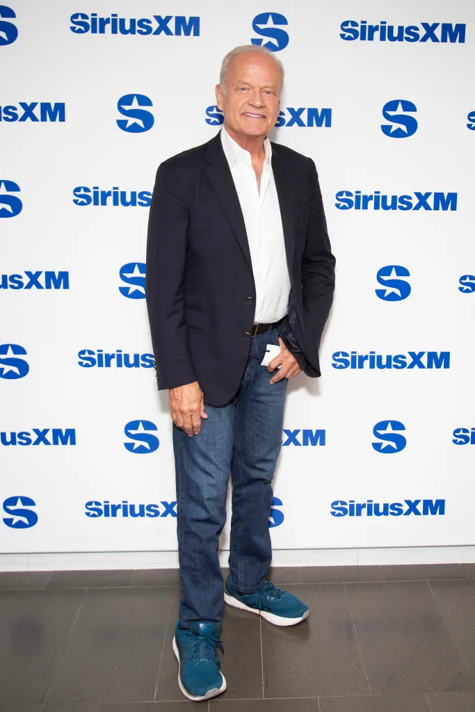 Kelsey Grammer standing in front of a white wall with blue SiriusXM logos.